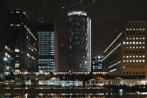 DLR train passes in front of modern buildings in Canary Wharf, London, UK. Stock Photos