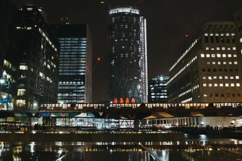 DLR train passes in front of modern buildings in Canary Wharf, London, UK. Stock Photos