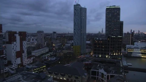 DLR train passing right to left wide shot at Canary Wharf train station at night Stock Footage 74285911