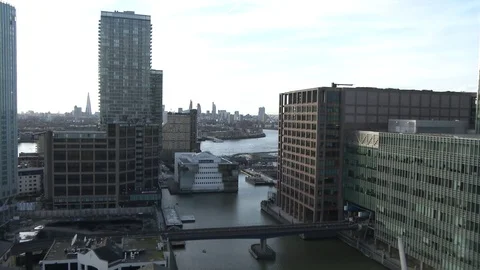 DLR train passing right to left wide shot at Canary Wharf train station at dusk  Stock Footage 74498864