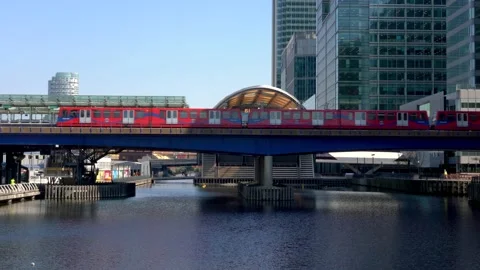 DLR Train passing through Canary Wharf financial district Stock Footage 153337076