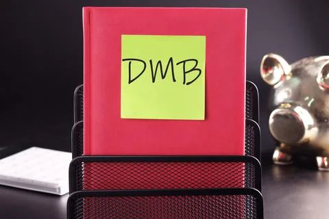 DMB text on a yellow sticker pasted on an upright diary on a black background Stock Photos