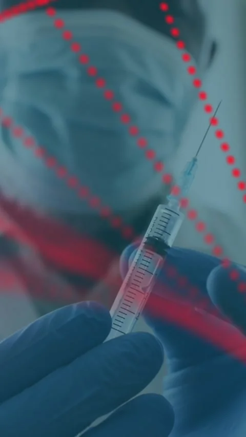 Dna structure spinning over male doctor wearing face mask tapping on syringe to Stock Footage 342004120