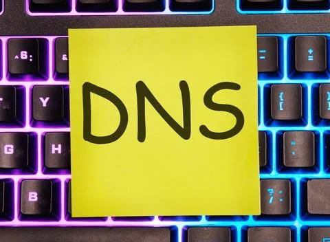 DNS -Domain Name Server written on a yellow sticker on a laptop keyboard with Stock Photos