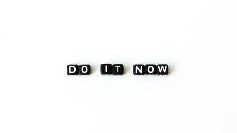 Do it now motivation quote in black letter beads on white background. Top view Stock Photos