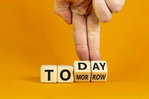 Do it today, not tomorrow. Male hand flips wooden cubes and changes the word  Stock Photos