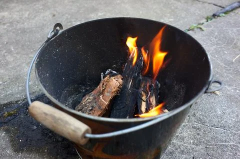 A Do it yourself backyard BBQ grill in  a bucket with sausages and potatoes Stock Photos