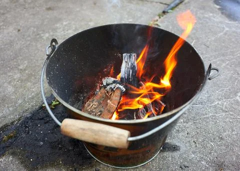 A Do it yourself backyard BBQ grill in  a bucket with sausages and potatoes 写真素材