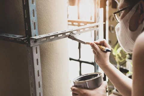 Do it yourself concept, Craftsmen use anti-rust paint to paint old iron parts Stock Photos