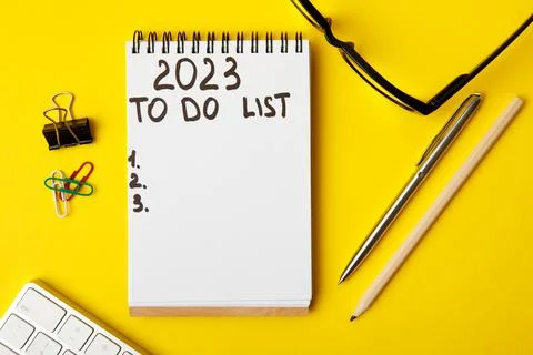 To do list 2023. Notepad and mobile phone on a yellow background. Stock-Fotos
