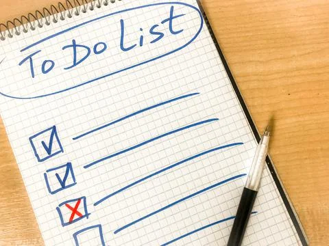 To do list checklist hand written on notepad paper lay on wooden table. pen l Stock-Fotos