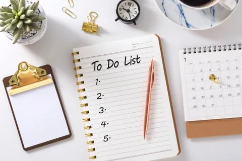 To do list in notebook with calendar,  clock and clipboard on white desk, gol Stock Photos