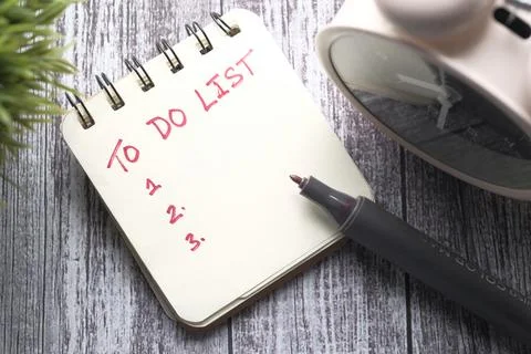 To do list in notebook with office suppliers on desk. Stock Photos