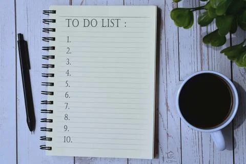 To do list on notepad with cup of coffee, pen and green leaf background Stock Photos