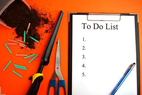 To do list. Notepad with a white sheet of paper, next to the ground, garden s Stock Photos