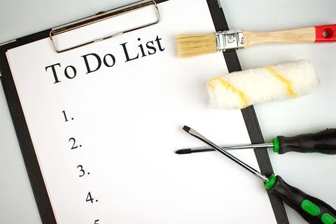To do list. Notepad with a white sheet of paper, next to brush, roller and ph Stock Photos