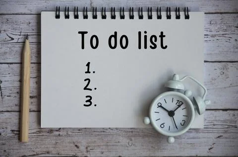 To Do List text on notepad - White alarm clock. Stock Photos