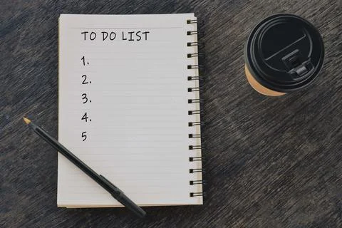 To Do List words written on on notepad with disposable coffee cup and pen. Stock Photos