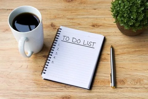 To do list written on notepad with pen, cup of coffee and flower on top of wo Stock Photos