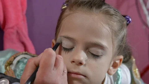 Do makeup to child. The mather paints the face of a little girl. Vídeo Stock 104909669
