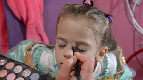 Do makeup to child. The mather paints the face of a little girl. Vídeos de archivo 104909926