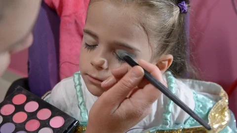 Do makeup to child. The mather paints the face of a little girl. Vídeos de archivo 104911166