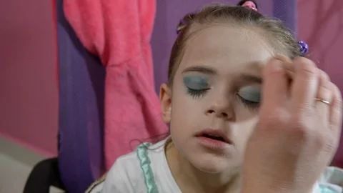 Do makeup to child. The mather paints the face of a little girl. 스톡 동영상 104911577