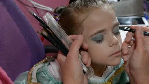 Do makeup to child. The mather paints the face of a little girl. Видео 104958803