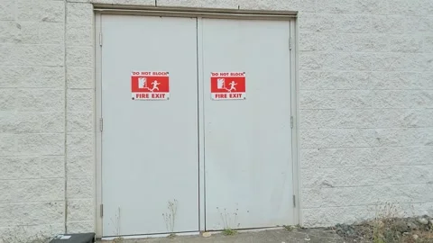 Do not block fire exit signs mounted on metal warehouse double doors Stock-Footage 342602496