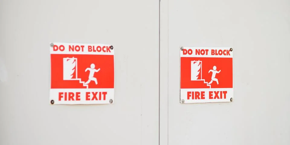 Do not block fire exit emergency signs on commercial white double doors Stock Photos