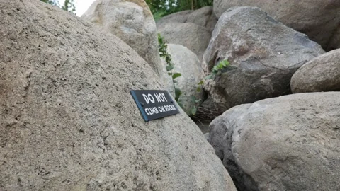 Do Not Climb on Rocks Sign | Handheld 4k 24fps Stock Footage 137418034
