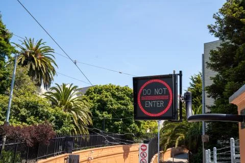 Do not enter neon lighter sign leading to pedestrian tunnel in sunny environment Stock Photos