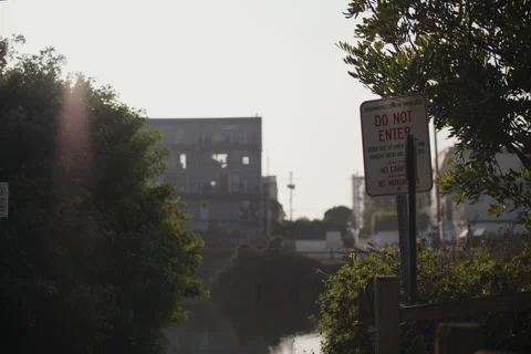 Do not enter sign, end of path, bushes, river, apartments, sun setting Stock Footage 296700769
