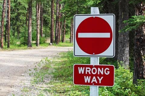 A do not enter, wrong way sign beside a gravel road Stock Photos