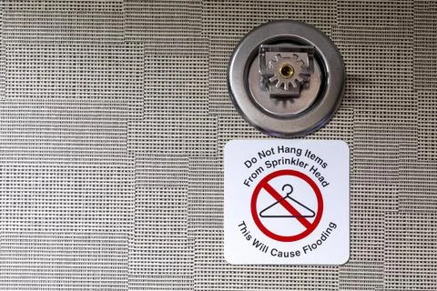 Do not hang items on sprinkler head, this will cause flooding sign attached t Stock Photos