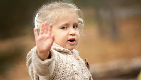 Do not shoot! Do not look at me! A little girl tired of attention, asks not t Stock Photos