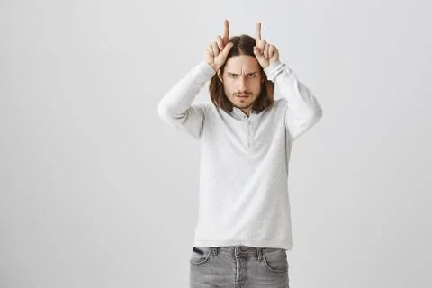 Do not wake devil in me. Studio shot of cute caucasian male in casual white Foto stock