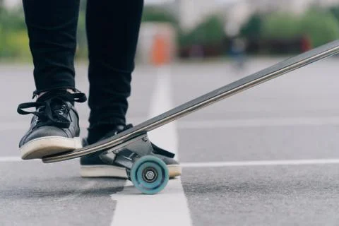 Do stunts on the longgord while riding on a board on the asphalt. Closeup of  Stock Photos