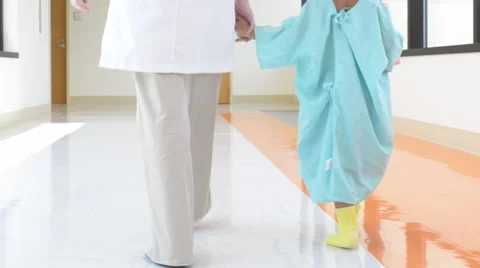 Doc and child walk down hospital hall Vidéo 40794576