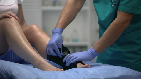 Doc fixing two-strap ankle wrap in proper position anti-inflammatory medication Vídeo Stock 117190300