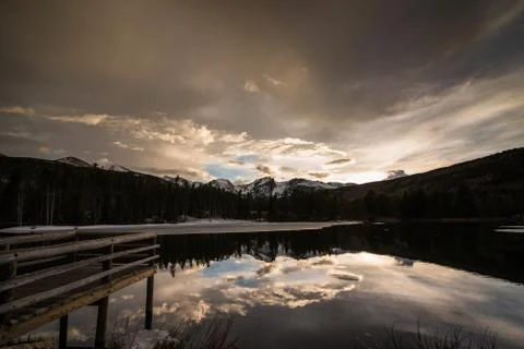 A dock looking out on a reflective pond. Stock Photos
