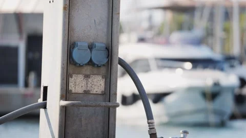 A Dock Post featuring multiple Electrical Outlets along with a Yacht in the Stock Footage 288116742