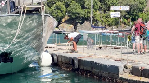 A Dock Worker Secures a Ferry Boat to a Stone Pier in Portofino Stock Footage 336715226