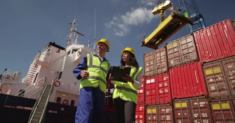 Dock workers discuss logistics at the harbor amidst shipping industry activity.  Stock Footage