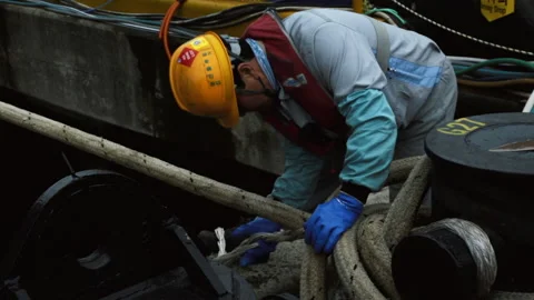 Dock workers unwind the mooring cable on the shore. Stock Footage 172395569