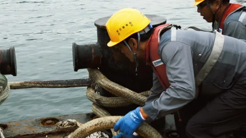Dock workers unwind the mooring cable on the shore. Stock Footage 172395617