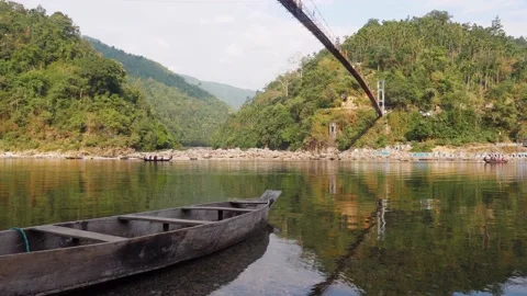 Docked boat in lake while a group of paddlers propelling a canoe in background Video stock 176800988