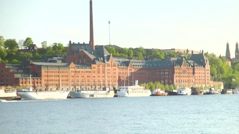 Docked boats in front of  a large building Stock Footage 241349550