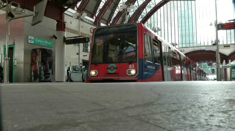 Docklands Light Railway driverless train pulling out of canary wharf DLR Stock Footage 875927