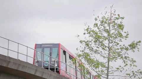 Docklands Light Railway train on bridge and tree 1 Stock Footage 52980735
